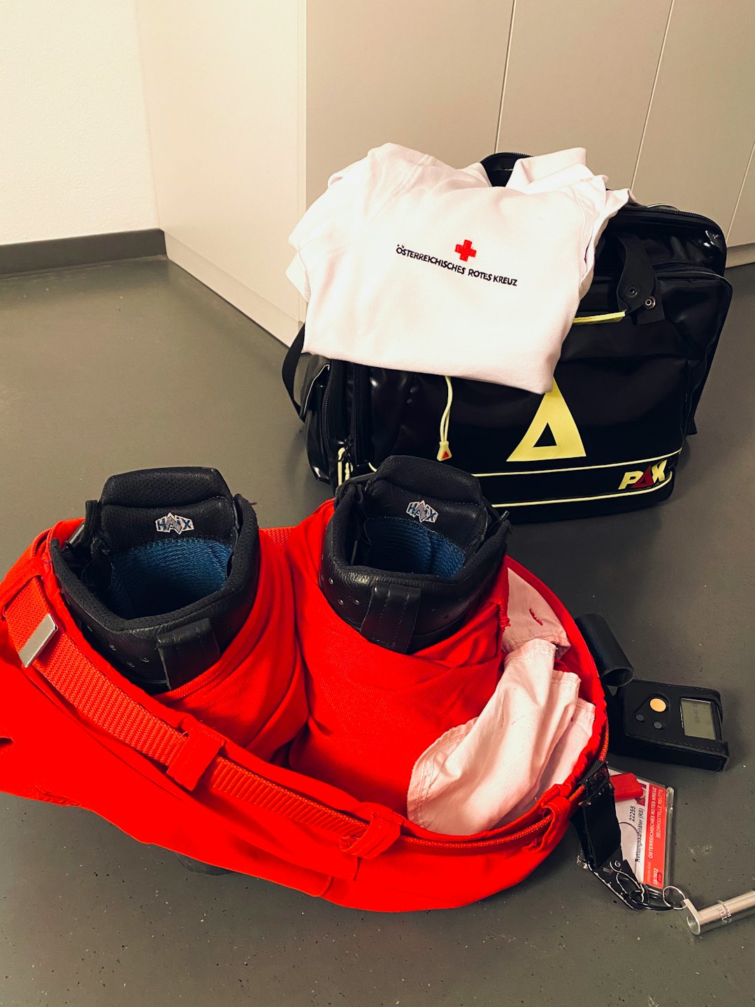 Emergency responder gear arranged neatly on a grey floor.