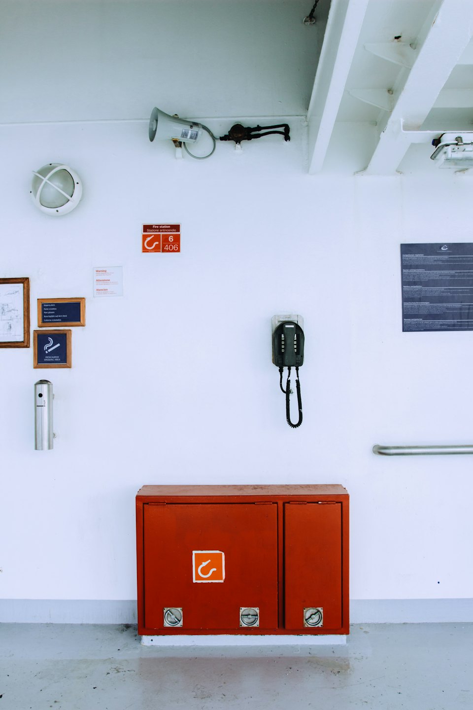 Safety equipment and communication devices mounted on a white wall.
